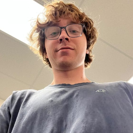 Jonathan, the developer of Slopverse, photographed from below under an office ceiling light.